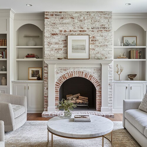 Flanking-the-fireplace-custom-built-in-cabinets-painted-soft-gray-provide-storage-and-display-space-holding-books-small-art-pieces